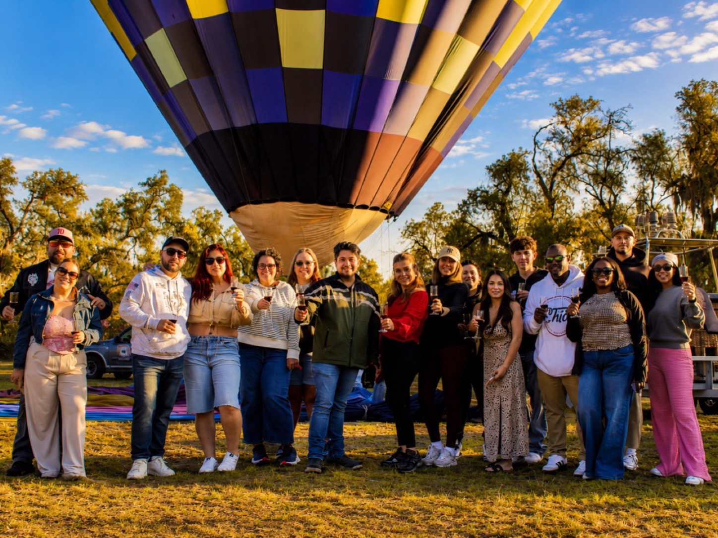 Guests posing beside a hot-air balloon before their flight